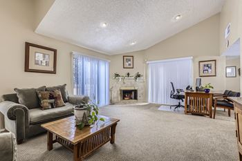 Hilltop View Clubhouse with a wooden coffee table, and a fireplace in Denver, CO